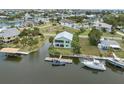 An aerial view of the home on the water, showing the back, dock, other neighborhood homes and water access at 5070 Cedarbrook Ln, Hernando Beach, FL 34607