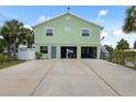 View of the two car garage, large driveway, door to the lower level and steps up to the main living area at 5070 Cedarbrook Ln, Hernando Beach, FL 34607