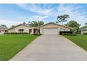 Well-maintained single-story home featuring a spacious driveway, lush lawn, and stone facade accents at 5078 Florentine Ct, Spring Hill, FL 34608