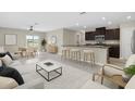 Bright, open-concept living room with tile floors, modern furniture, and a view into the dining area at 5432 Rainwood Meadows Dr, Apollo Beach, FL 33572