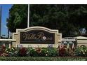 Villa Rosa community sign surrounded by colorful flowers and manicured greenery at 5519 Reflections Blvd, Lutz, FL 33558