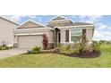 Well-maintained single-story home with a two-car garage, stone accents, and lush landscaping at 5620 Night Owl Ter, Palmetto, FL 34221