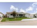 Welcoming single-story home with a covered front porch, a tidy lawn, and an attached garage at 5840 Liddell Dr, New Port Richey, FL 34652