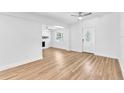 Bright, open living room featuring hardwood floors, a stone fireplace, and modern ceiling fans at 5927 10Th N St, St Petersburg, FL 33703