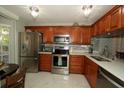 Well-equipped kitchen with stainless steel appliances and wooden cabinetry at 6424 Thicket Trl, New Port Richey, FL 34653