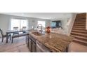 Modern kitchen island with a stainless steel sink, granite countertop, and seating at 7641 Sail Clover Ln, Zephyrhills, FL 33540