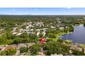 Aerial view showcasing the home's location near a serene lake and lush greenery, with a city skyline in the distance at 10310 Carroll Cove Pl, Tampa, FL 33612