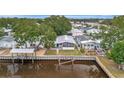 Waterfront property featuring a dock, screened-in porch, and meticulously maintained grassy yard at 106 N Saint George Cir, Apollo Beach, FL 33572