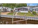 Waterfront property with screened-in porch, dock, and lush green lawn perfect for outdoor enjoyment at 106 N Saint George Cir, Apollo Beach, FL 33572