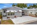 Inviting single-story home featuring awnings, carport, and landscaped front yard with vibrant flowers at 106 N Saint George Cir, Apollo Beach, FL 33572