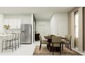 Bright dining area featuring modern appliances, a dining table, and a view of the kitchen at 11729 Brae Way, Dade City, FL 33525