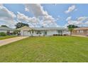 Charming home featuring a well-manicured lawn, complemented by a white exterior and vibrant, decorative accents at 1224 W Del Webb Blvd, Sun City Center, FL 33573