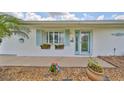 Inviting front entrance with colorful flowers accenting the turquoise door and shutters, creating a cheerful curb appeal at 1224 W Del Webb Blvd, Sun City Center, FL 33573