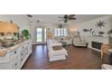 Bright living room features hardwood floors, white furniture, decorative fireplace, and natural light at 1224 W Del Webb Blvd, Sun City Center, FL 33573
