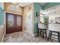 Inviting foyer featuring a decorative glass double door, stylish flooring, and access to the kitchen at 13386 Lawrence St, Spring Hill, FL 34609