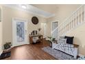 The bright foyer has wood floors, a staircase, and a decorative glass front door at 13913 Felix Will Rd, Riverview, FL 33579