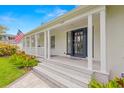 Home featuring a welcoming front porch, elegant door, and manicured landscaping at 146 26Th Ne Ave, St Petersburg, FL 33704