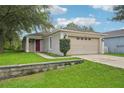 Charming single-story home with a two-car garage, well-maintained lawn, and beautiful landscaping at 1502 Marsh Wood Dr, Seffner, FL 33584