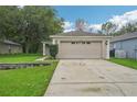 Charming single-story home with a spacious driveway, two-car garage, and manicured lawn at 1502 Marsh Wood Dr, Seffner, FL 33584