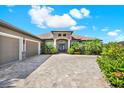 Attractive house with a paved driveway and a charming entryway enhanced by palm trees and tropical foliage at 15415 Mulholland Rd, Parrish, FL 34219