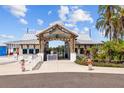 Entrance to Southshore Bay featuring a wooden archway and well-manicured landscaping at 17005 Avon Dive Ln, Wimauma, FL 33598