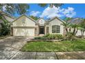 Charming single-story home featuring a well-manicured lawn and a brick-paved driveway at 17910 Timber View St, Tampa, FL 33647
