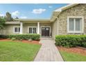 Close-up view of a home's inviting entrance with a brick path, stone accents, and manicured shrubs at 1803 143Rd E Ct, Bradenton, FL 34212