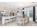Modern kitchen with stainless steel appliances, a center island, and an adjacent dining area at 1959 Longliner Loop, Wesley Chapel, FL 33543