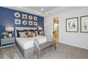 Stylish primary bedroom with a decorative wall, a king-sized bed, and an ensuite bathroom at 1959 Longliner Loop, Wesley Chapel, FL 33543