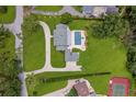 Aerial view of estate showcasing pool, tennis court, circular driveway, lush landscaping, and sprawling grounds at 2395 Campbell Rd, Clearwater, FL 33765