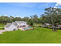 Expansive backyard featuring a swimming pool, lush greenery, and a covered patio perfect for outdoor entertaining at 2395 Campbell Rd, Clearwater, FL 33765