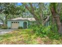 Charming single story home with a yard featuring mature landscaping and an arched entrance at 2418 Deltona Blvd, Spring Hill, FL 34606