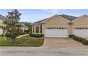 Charming single-story home with brick driveway, manicured landscaping, and an attached two-car garage at 2616 Tottenham Dr, New Port Richey, FL 34655