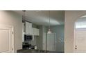 An open kitchen with stainless appliances, granite countertops, and bright lighting fixtures at 2822 Jacob Crossing Ln, Holiday, FL 34691
