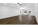 Open-concept living room featuring modern flooring and a ceiling fan, with a view into the bright kitchen at 29595 Fedora Cir, Brooksville, FL 34602