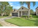 Inviting single-Gathering home displays a lush green lawn, a two-car garage, and a quaint covered entry at 30753 Pumpkin Ridge Dr, Wesley Chapel, FL 33543