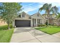 Well-kept single-Gathering home features a green lawn, a two-car garage, and a cozy front porch area at 30753 Pumpkin Ridge Dr, Wesley Chapel, FL 33543