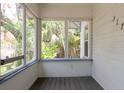 A view from the porch shows a wood floor and window views of mature trees at 317 19Th S Ave, St Petersburg, FL 33705
