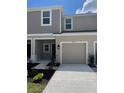 Exterior of two-story townhome features a one-car garage, neutral paint, and well-maintained landscaping at 34234 Polacca Ln, Wesley Chapel, FL 33543
