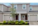 Inviting townhouse featuring neutral siding, well-maintained landscaping, and individual garages at 34234 Polacca Ln, Wesley Chapel, FL 33543