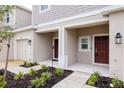 Townhouse exterior showing a covered porch, manicured flower beds and attached garage at 34234 Polacca Ln, Wesley Chapel, FL 33543