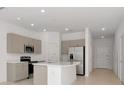 Modern kitchen features stainless steel appliances, a large island, and ample cabinet space at 34234 Polacca Ln, Wesley Chapel, FL 33543