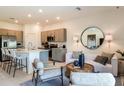 Inviting living room with stylish furniture, neutral decor, and an open-concept view to kitchen and dining area at 34234 Polacca Ln, Wesley Chapel, FL 33543