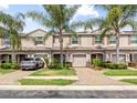 Well-manicured townhouse exterior boasts one car garage, brick paved driveway, and lush landscaping at 3901 Silverlake Way, Wesley Chapel, FL 33544