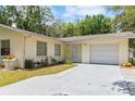 Charming single-story home with a manicured lawn, a one-car garage, and a concrete driveway at 39721 Meadowood Loop, Zephyrhills, FL 33542