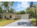 Charming single-story home with a well-maintained lawn, a one-car garage, and a long driveway at 39721 Meadowood Loop, Zephyrhills, FL 33542