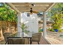 Outdoor patio features stylish dining set, ceiling fan, and view of the lush, private backyard and shed at 4616 S Matanzas Ave, Tampa, FL 33611