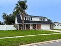Charming two-story home featuring a well-maintained lawn, a brick facade, and a white picket fence at 4725 Soapstone Dr, Tampa, FL 33615