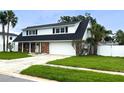 Charming two-story home featuring a well-maintained lawn, a brick facade, and a two-car garage at 4725 Soapstone Dr, Tampa, FL 33615