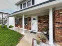 Inviting front porch with brick accents, white columns, and decorative plants offering curb appeal at 4725 Soapstone Dr, Tampa, FL 33615